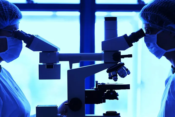 Scientists using microscopes